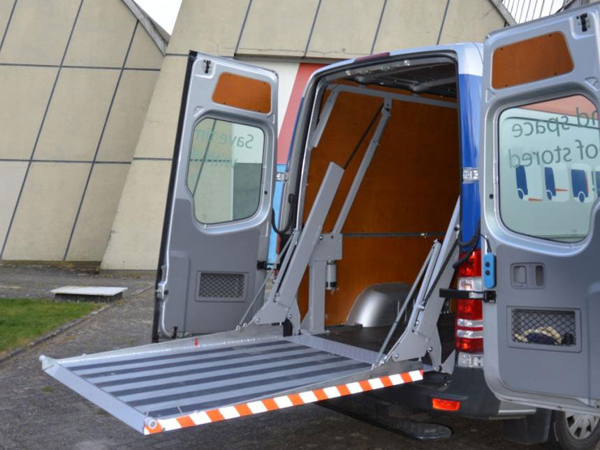 Bestelwagen met laadklep open voor lossen.